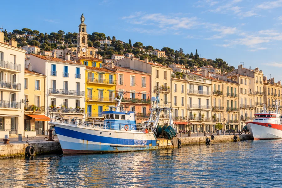 Un chalutier amarré dans le port de Sète, devant les façades colorées et le mont Saint-Clair